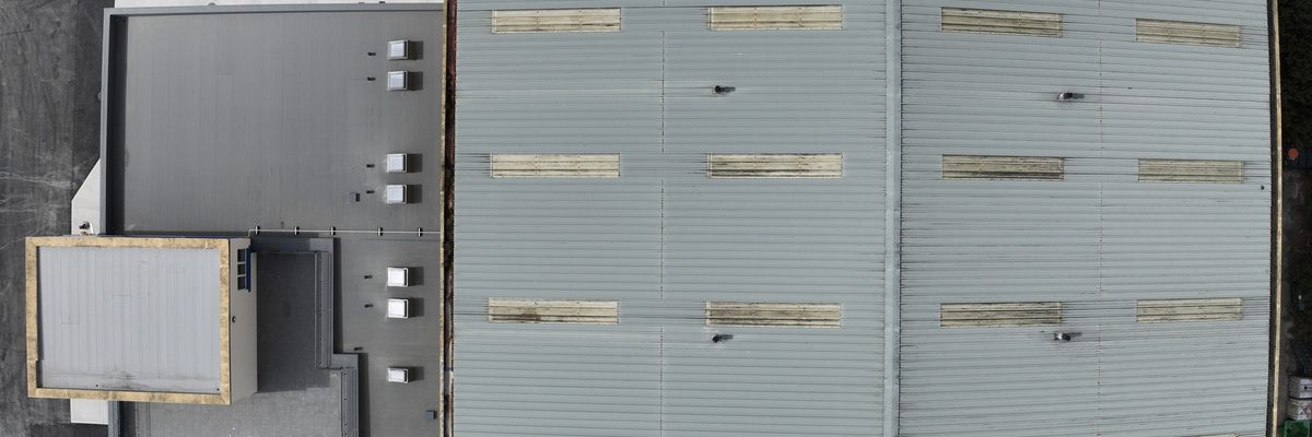 Aerial view of the steel-clad hangar building at Waterford Airport, with the two large doors at the front of the building