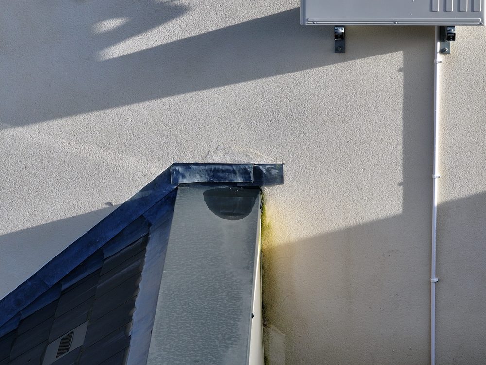 A further example of defective flashing on a housing unit roof showing the defect area