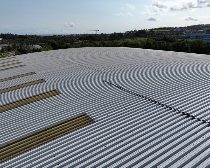 Aerial view along the roof of a large Dublin warehouse, with bands of translucent roof panels