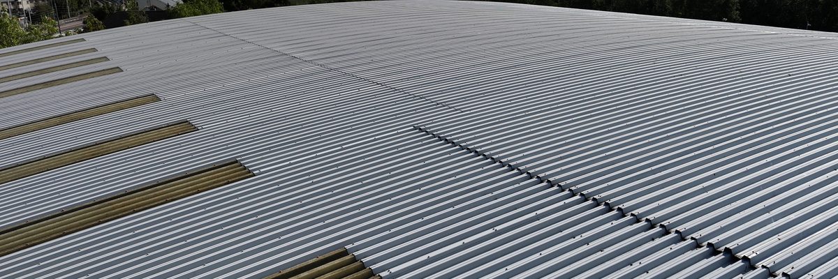 Aerial view along the roof of a large Dublin warehouse, with bands of translucent roof panels set into the sheeting