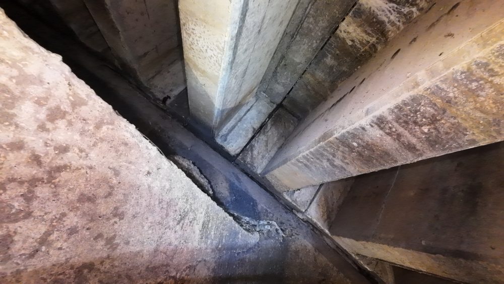 The upper interior of a spillway showing concrete flats and debris from original construction