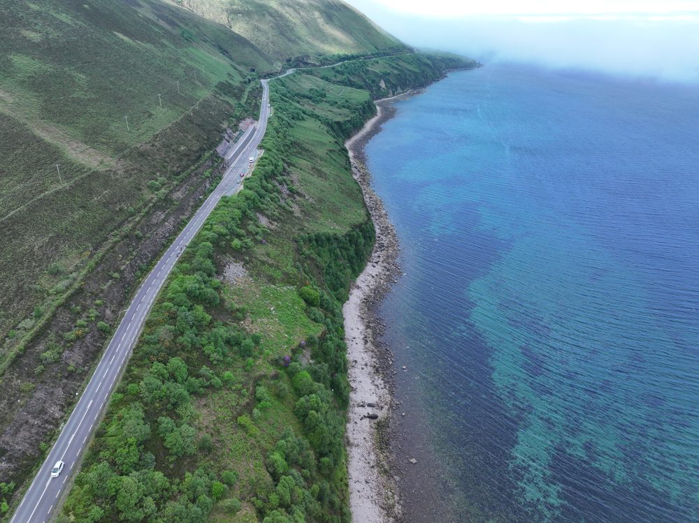 Aerial view of the coastal road running between the mountain and the sea at Mountain Stages, Kerry