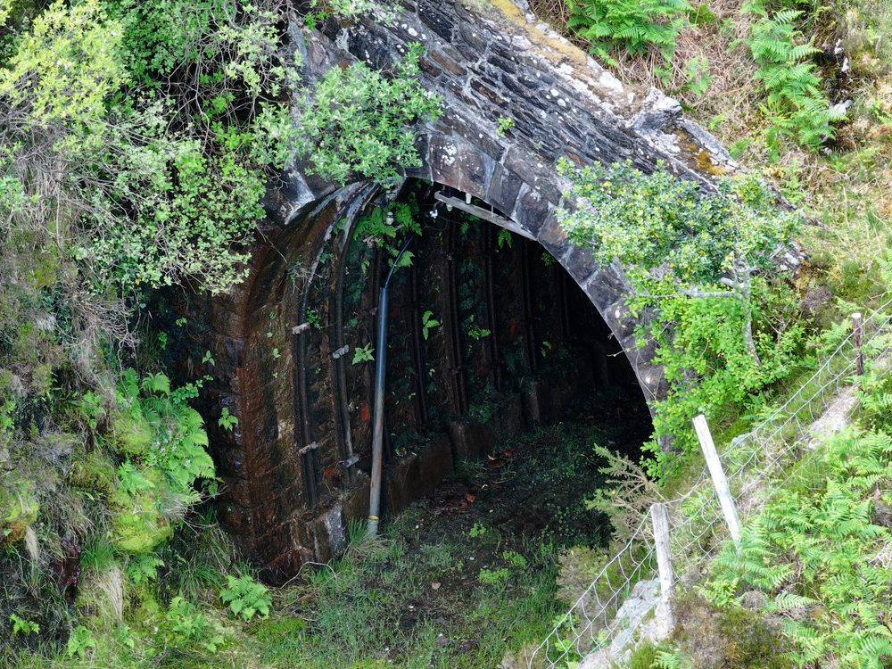 Close-up detail of erosion and defect features along the cliffside road embankment