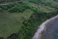 Aerial view of the cliffside road and surrounding coastline at Mountain Stages