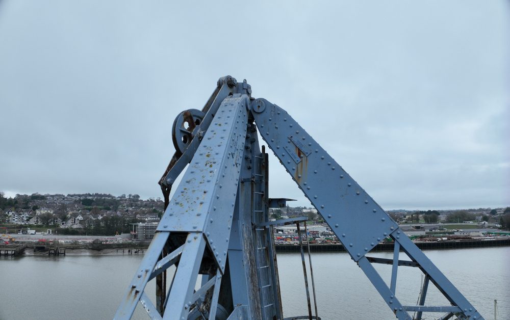 View up along the length of the crane's lattice jib from beneath