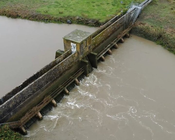 Wide aerial view of the complete barrage structure and surrounding riverbanks