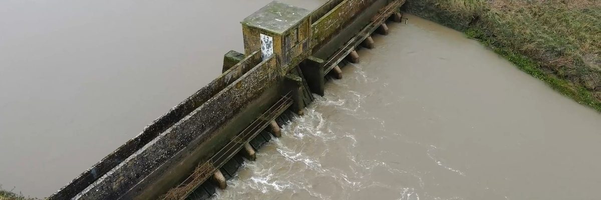 Wide aerial view of the complete barrage structure and surrounding riverbanks