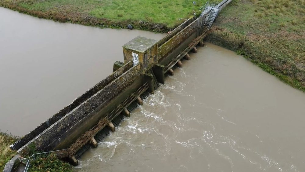 Wide aerial view of the complete barrage structure and surrounding riverbanks