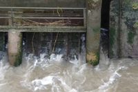 Close-up view of water discharging through the open barrage gates