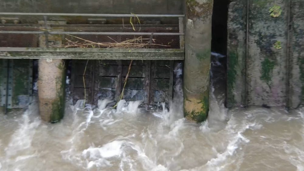 Close-up view of water discharging through the open barrage gates
