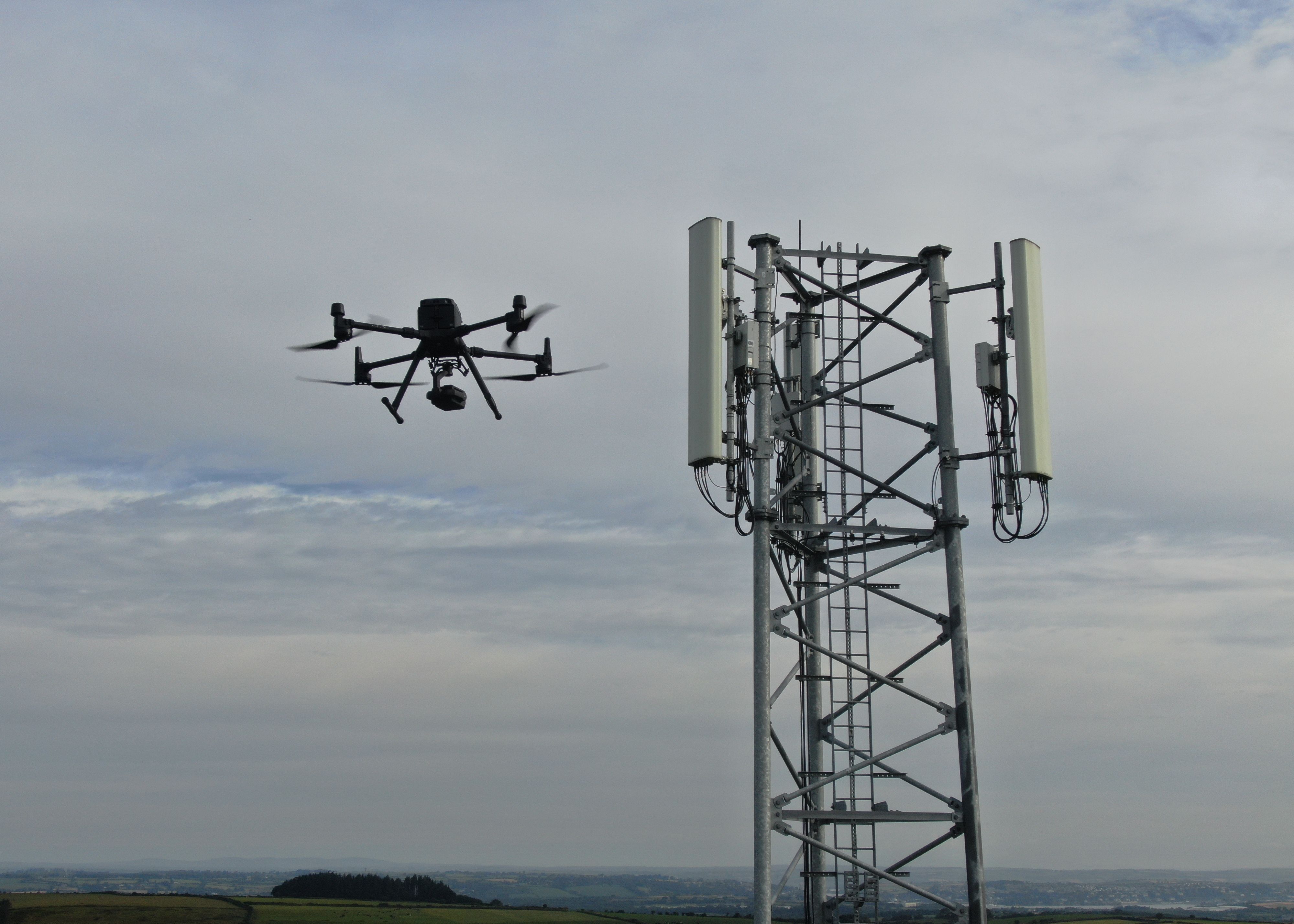 A cell phone tower being inspected by a drone