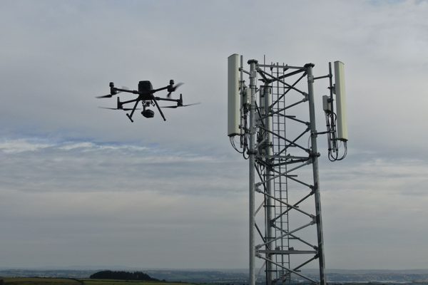 A cell phone tower being inspected by a drone
