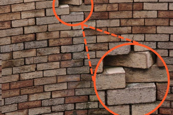 A concrete chimney stack with defects highlighted on the drone inspection imagery