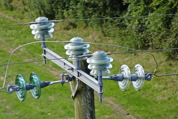 A detailed photo of the top of an electrical pole being inspected