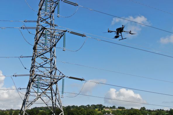 A drone inspecting a high-value asset like an electrical pylon