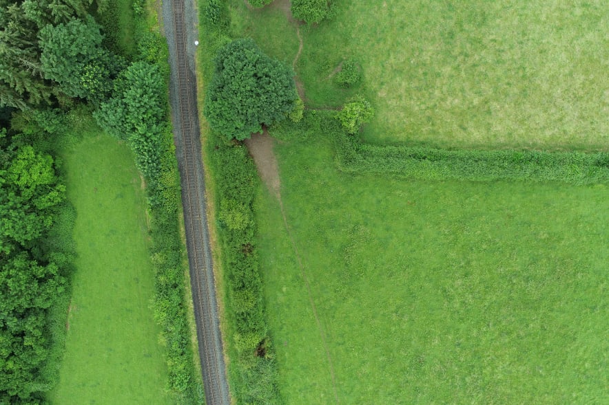 Farm land with trees and fields and a railway line
