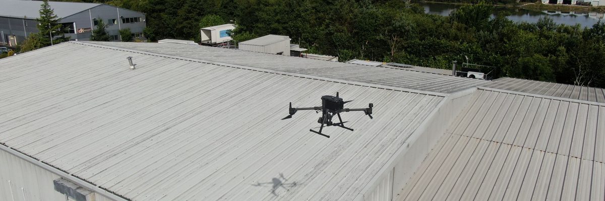 A drone view of a large industrial building roof during a drone roof inspection