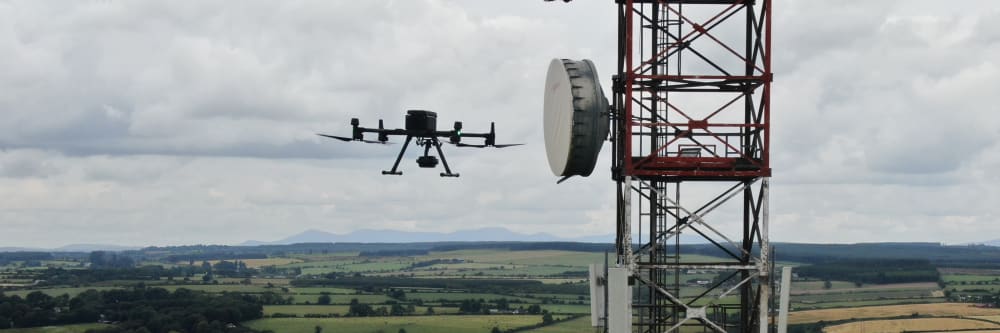 A telecommunications tower being inspected by a drone