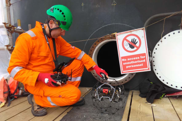 A man with a confined space drone ready to fly in a tank
