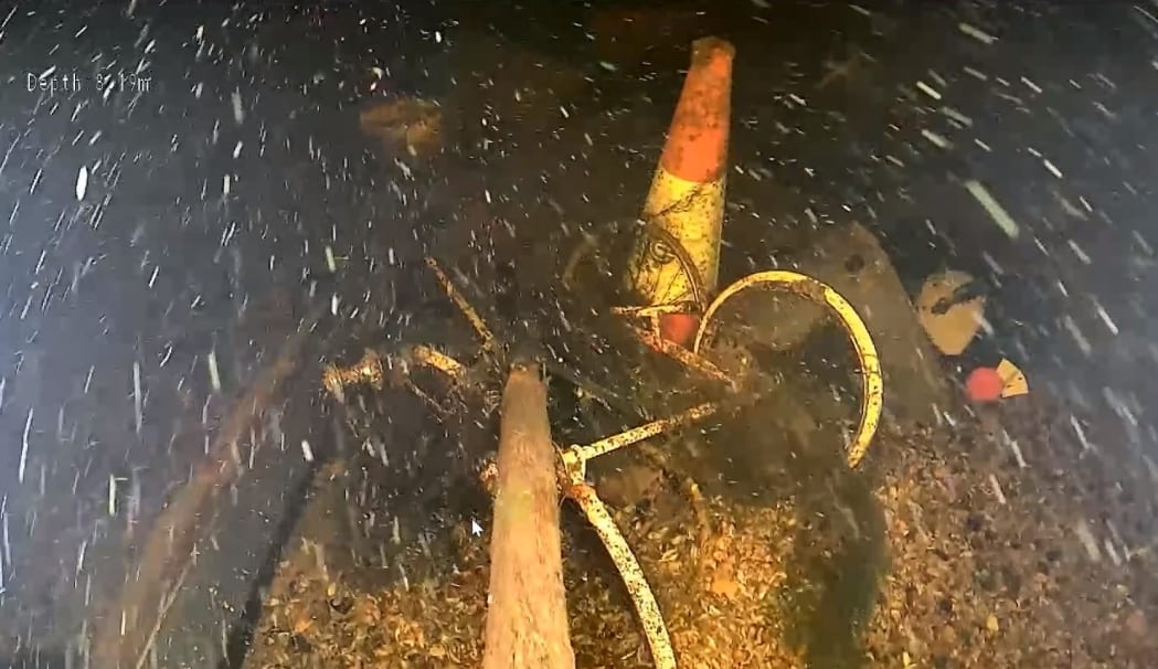 Underwater ROV footage showing accumulated debris in canal bed depression