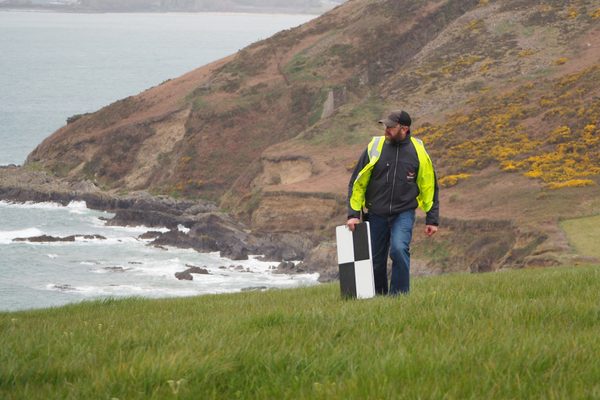 A person laying out GCPs near the sea