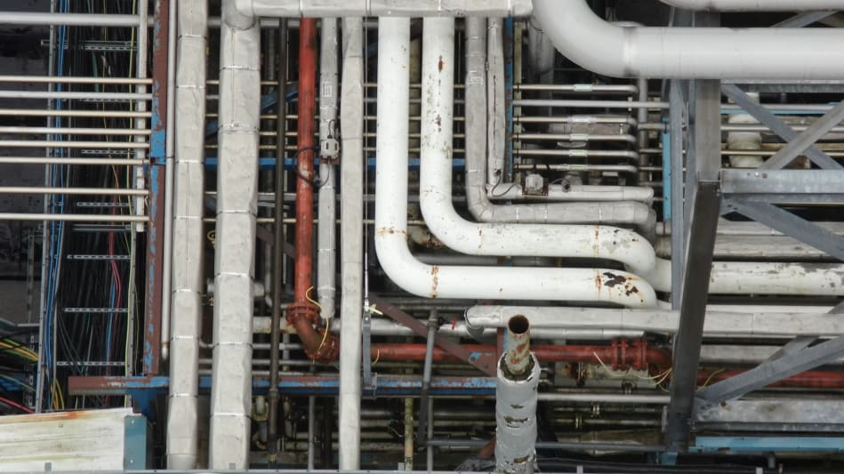 Pipes and electrical cable trays with debris present