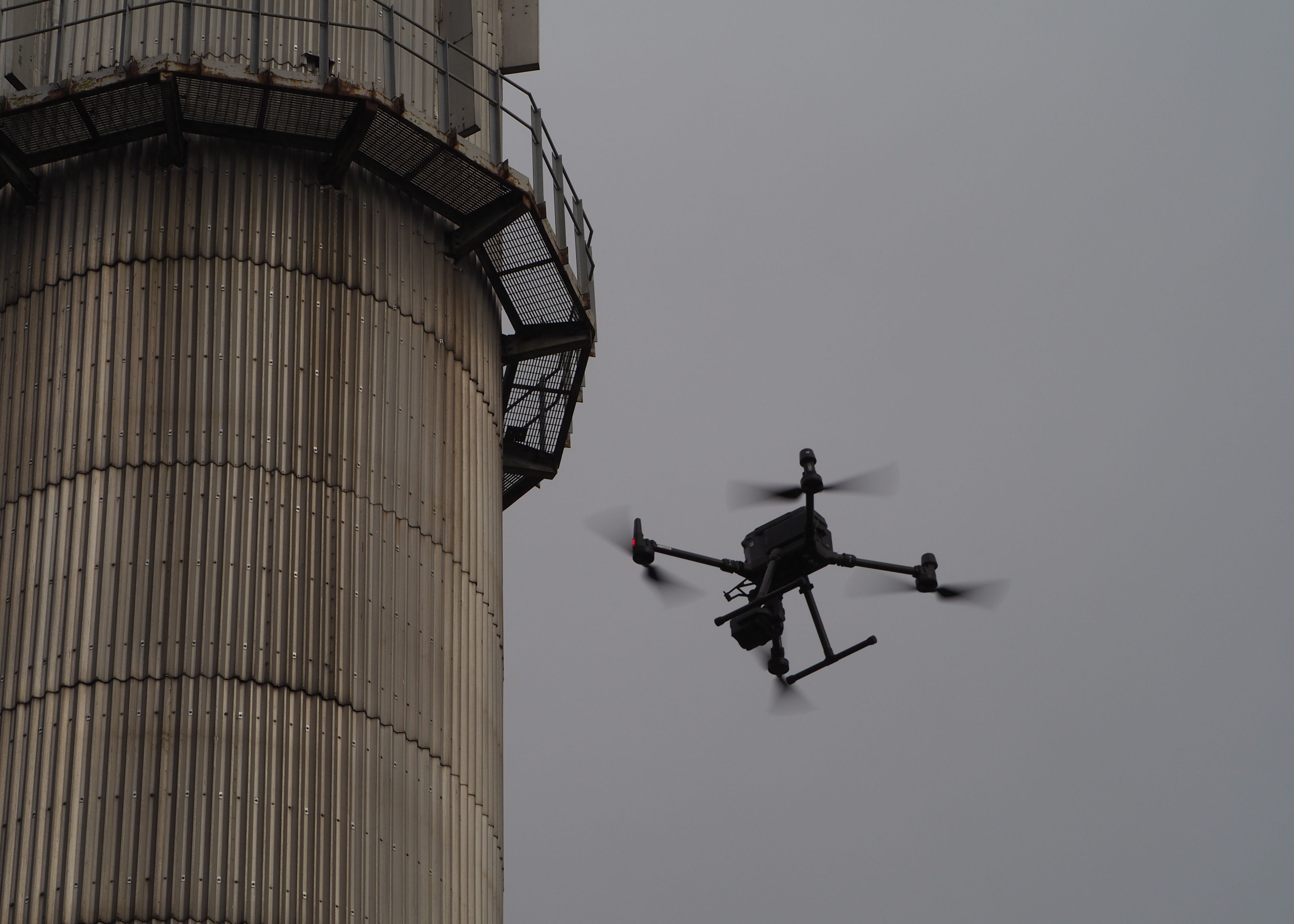 A drone inspecting an industrial chimney stack